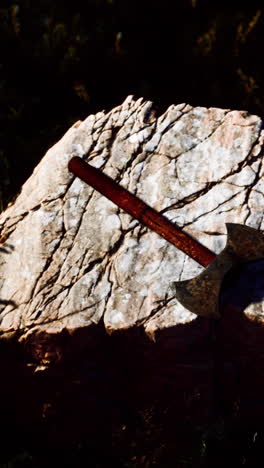 close up of an axe laying on a stone