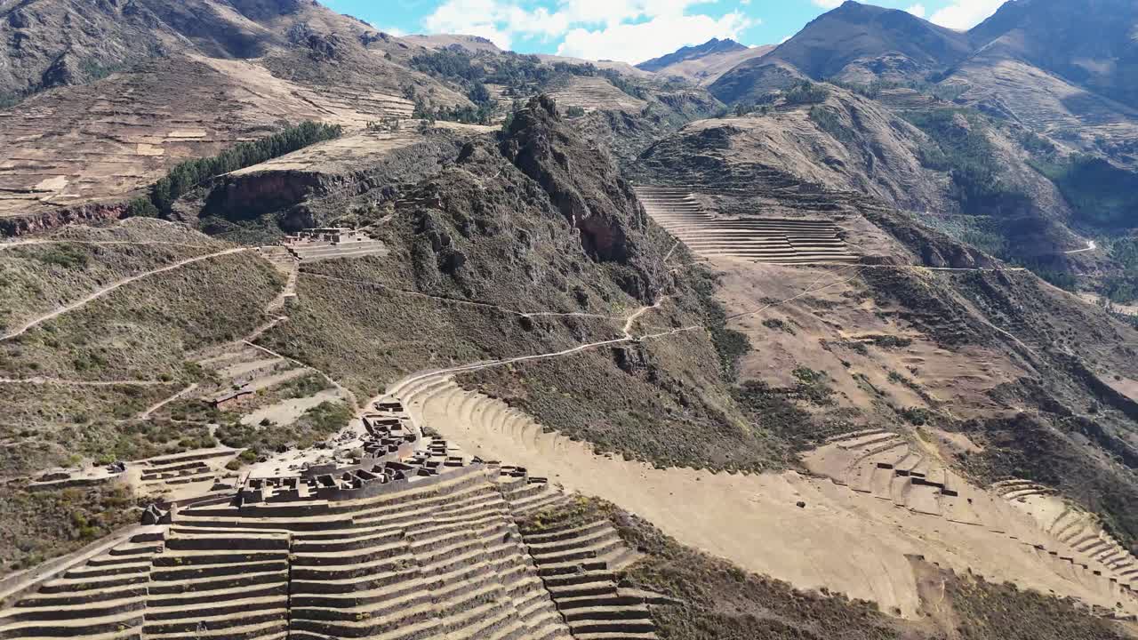 Aerial view of the ancient Inca ruins of Pisac in Peru’s Sacred Valley, showing terraced ruins and surrounding Andean mountains