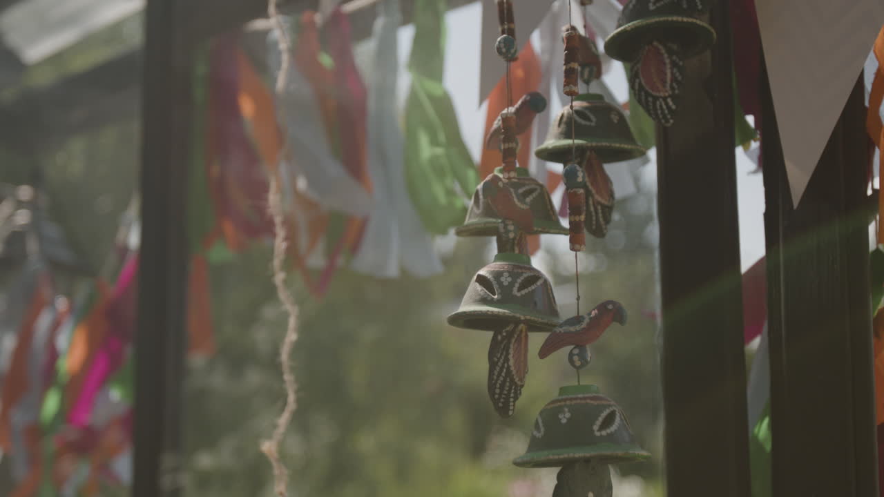 Decorative wind chimes and colorful ribbons hanging outdoors