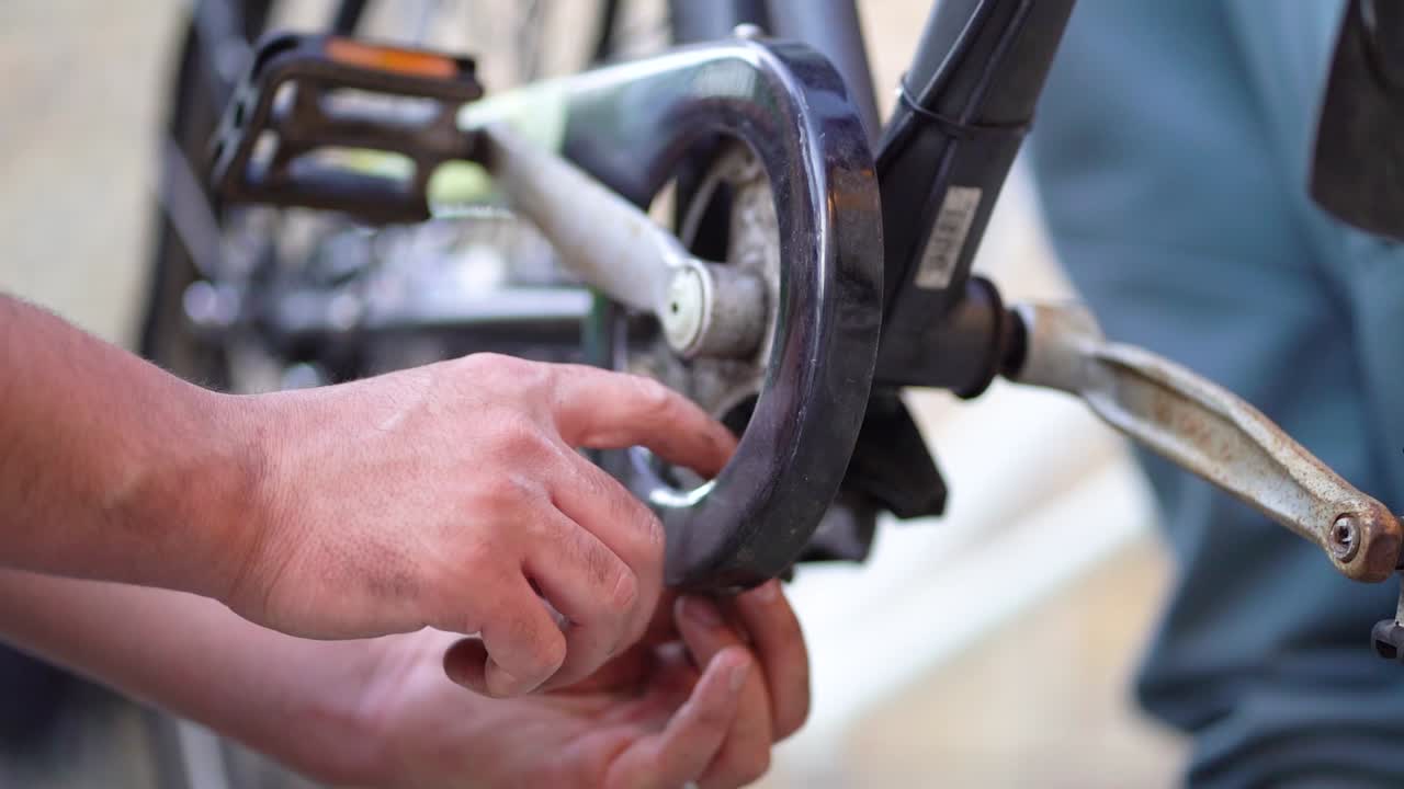 Caucasian male mechanic hands inserting steal clip to bicycle pedal, close up static