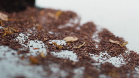 green tea spilling out of the container onto the table in slow motion