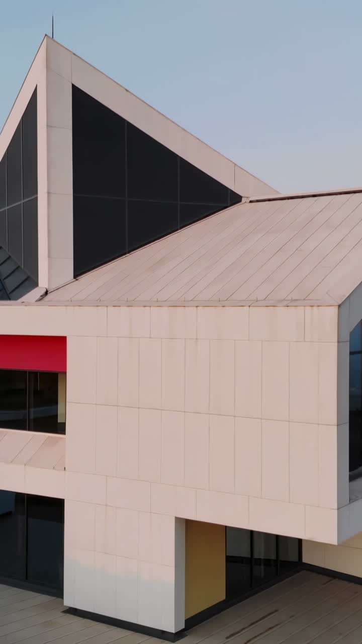 Vertical video: Clip pan starting, camera revealing exterior showing triangular roof and glass wall