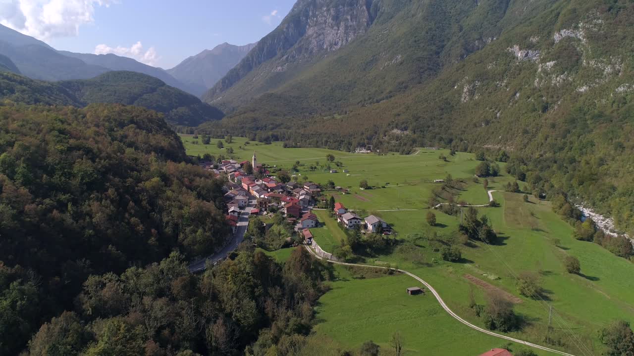 Aerial background drone view of a small alpine town, near soca river, on a sunny summer day, in the Julian alps, Slovenia