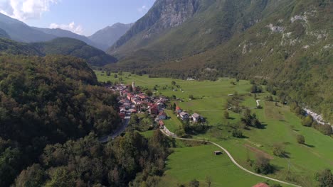 aerial background drone view of a small alpine town, near soca river, on a sunny summer day, in the julian alps, slovenia