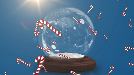 Multiple-candy-cane-icons-falling-over-shooting-star-spinning-around-snow-globe-on-blue-background