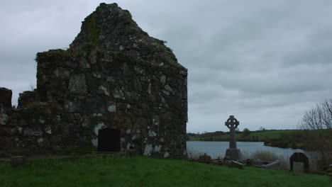 Ruina-De-Una-Antigua-Iglesia-De-Piedra-Con-Tumbas-Sobre-El-Lago-De-Irlanda