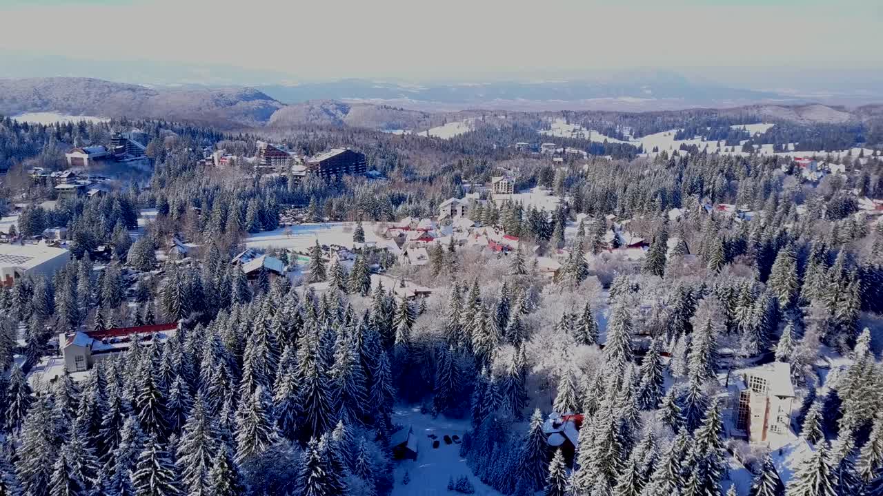 volando sobre el bosque nevado mirando hacia la ciudad de brasov