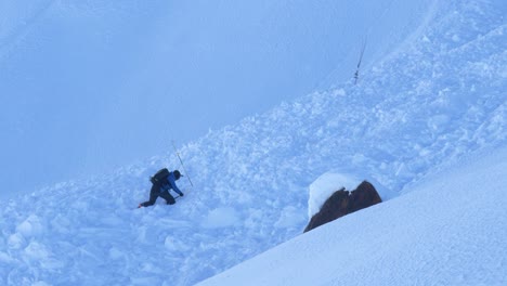 一名人在雪堆中寻找幸存者,雪崩后 - 静态视图