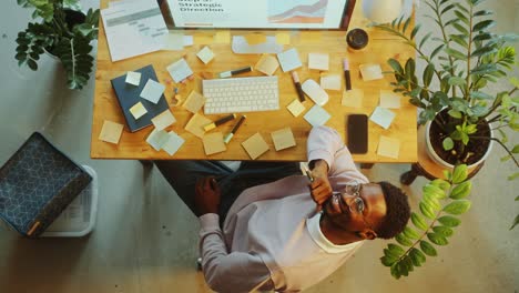 top down of african american man sitting at desk and smiling at camera