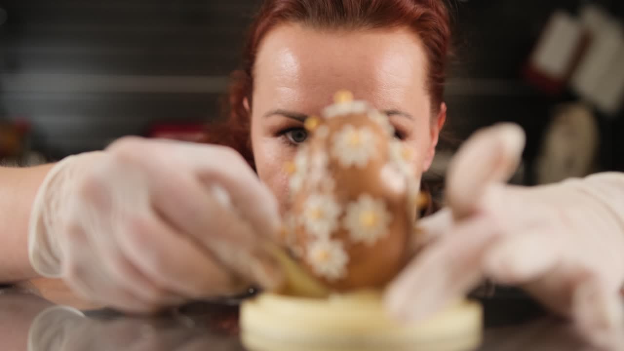 Donna che decora un uovo di Pasqua di cioccolato