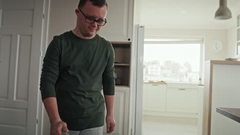 caucasian man with down syndrome vacuuming at home.