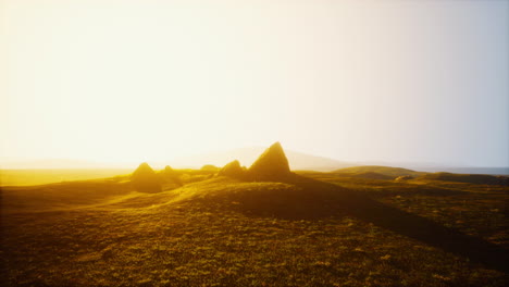 stunning sunrise over a grassy field with mountains in the distance