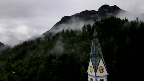 Slovenia-Small-Town-Surrounded-By-Misty-Pine-Forest-Mountains-Aerial-Drone-5