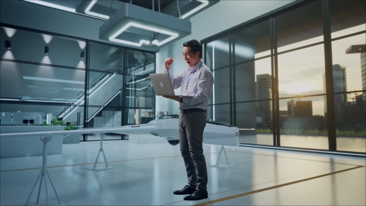 ingeniero emocionado celebrando el éxito en la computadora portátil