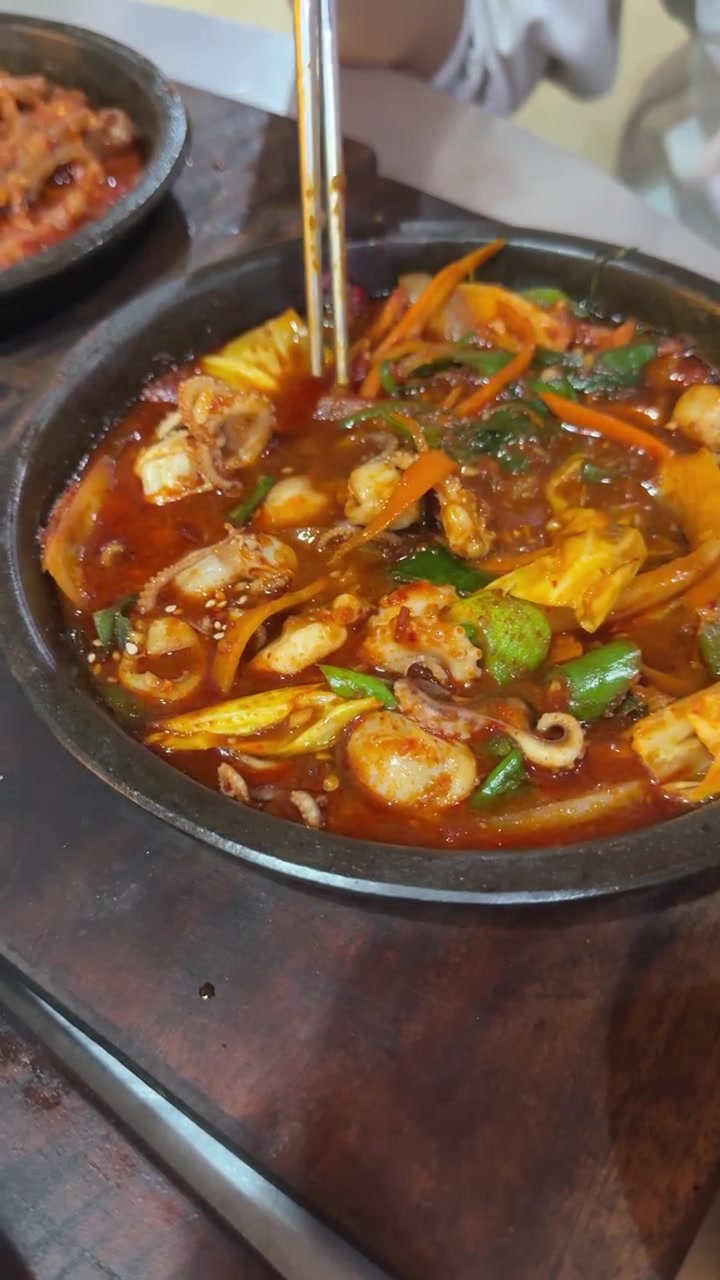 Seseorang Makan Gurita Tumis Pedas di Restoran Korea