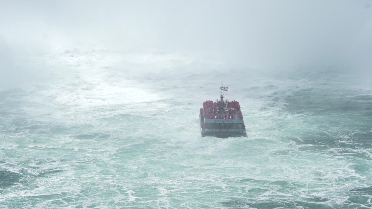 관광객들로 가득 찬 배는 나이아가라 협곡의 폭포에 접근하고 있습니다.