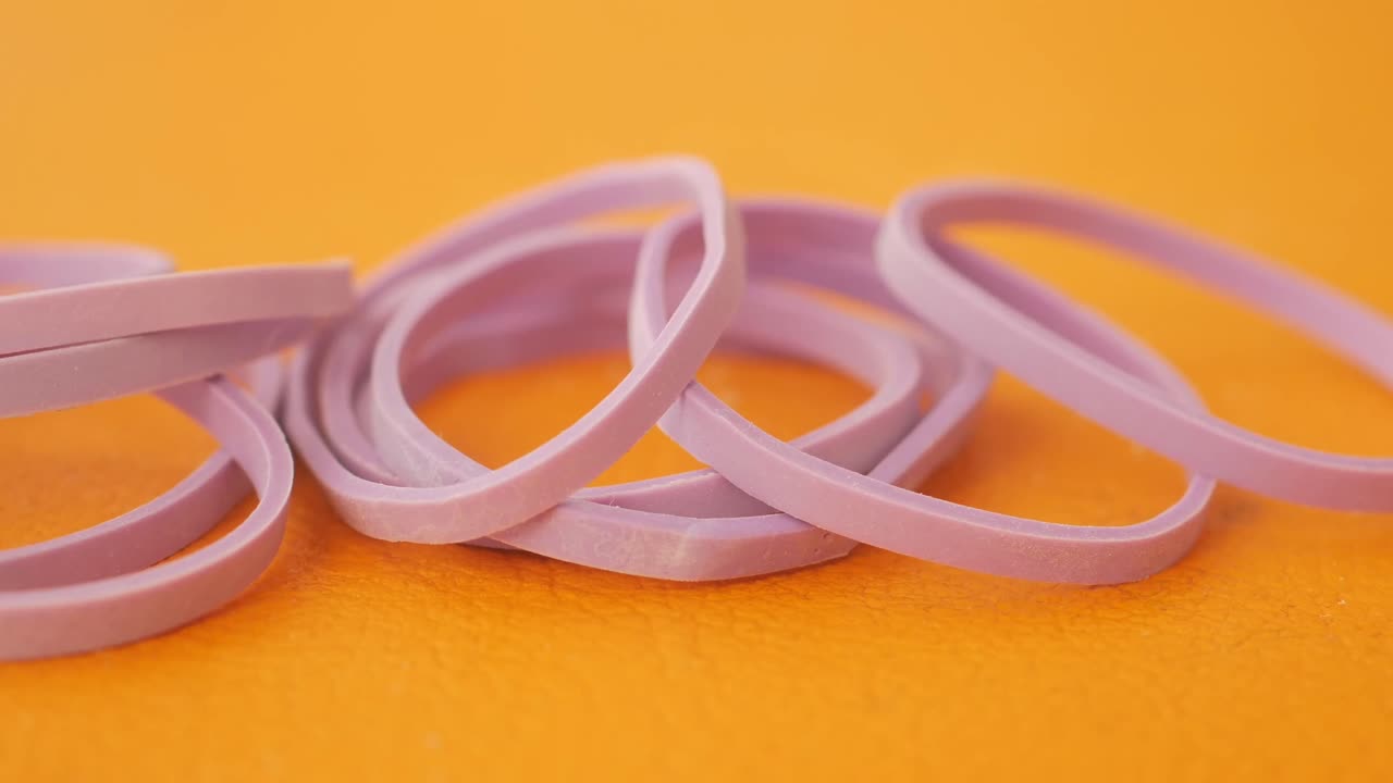 Purple Rubber Bands on Orange Surface