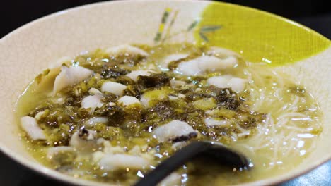 a bowl of noodle soup with vegetables and meat