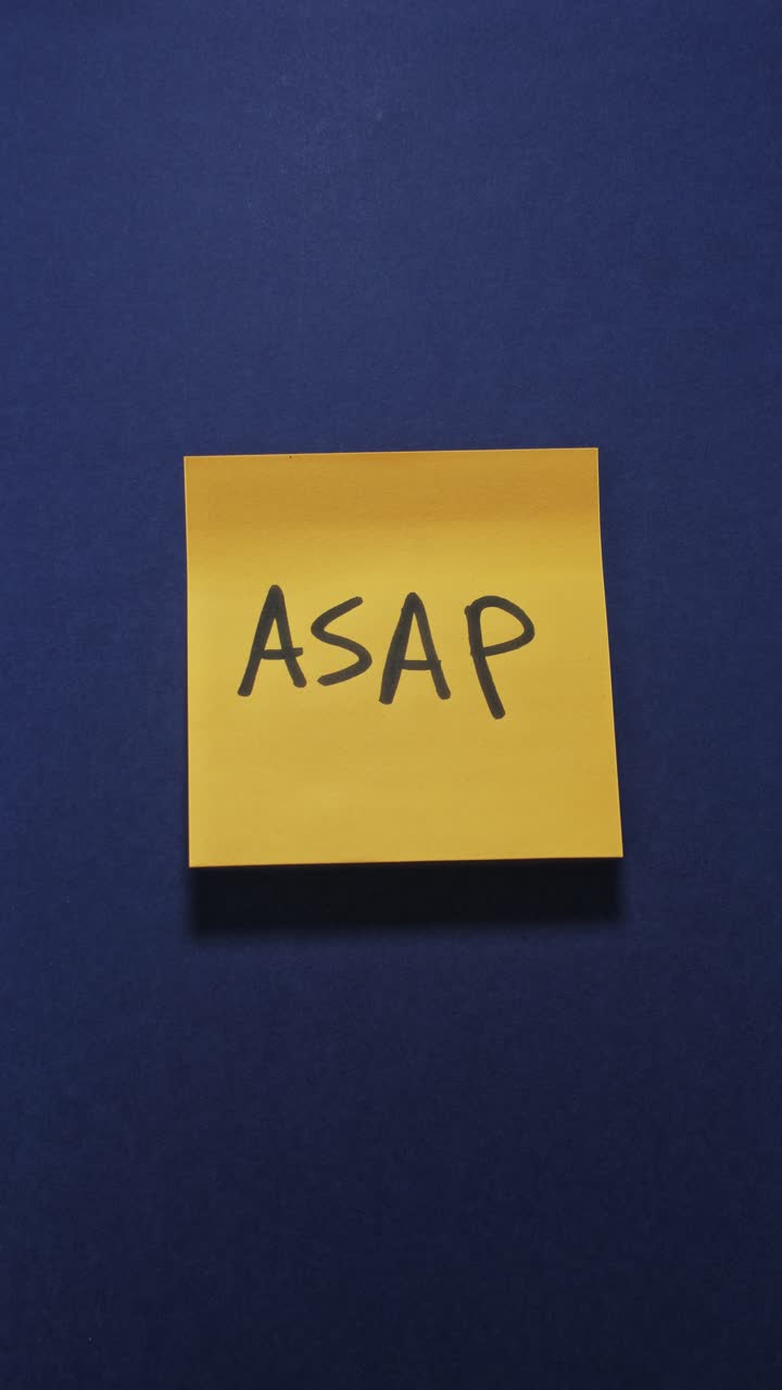 Hands posting ASAP sticky note on dark blue wall, highlighting priority tasks