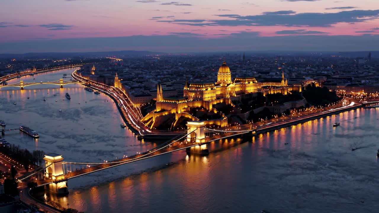 Veduta aerea di un paesaggio urbano al tramonto, con ponti e edifici illuminati lungo un fiume