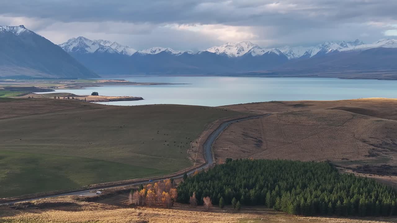 vista aérea de la carretera a lo largo del lago tekapo y los picos nevados de los alpes del sur, paisaje de nueva zelanda