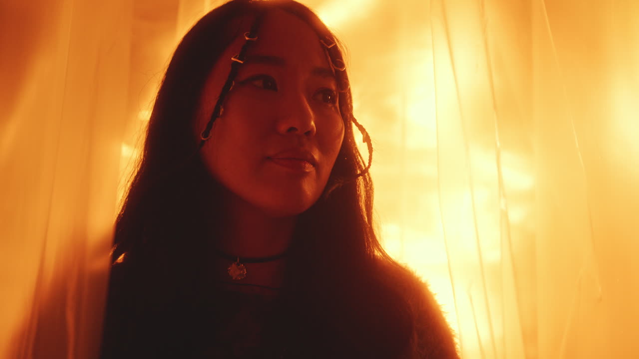 Beautiful Asian Girl Gazing Away Dreamily in Studio with Warm Light