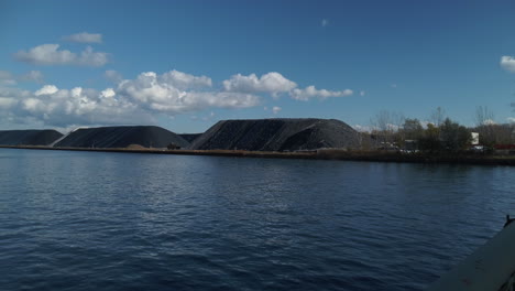 wide shot of toronto shipping channel with large salt storage mounds in view