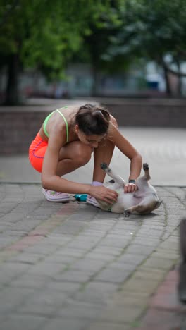 woman playing with her pug in a park