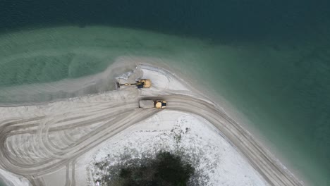 Vista-Alta-De-Un-Camión-Volquete-Que-Transporta-Arena-A-Lo-Largo-De-Un-Promontorio-Costero-Para-Un-Proyecto-De-Reposición-De-Erosión