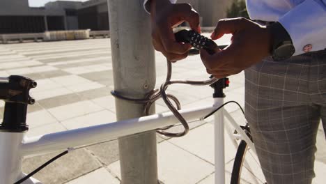 Hands-on-african-american-man-fastening-bike-in-the-city