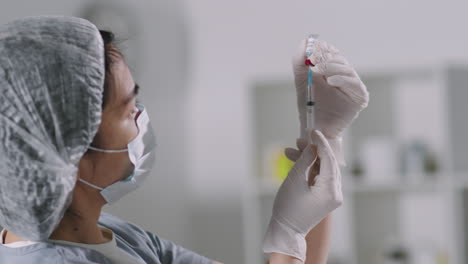 doctor filling syringe with covid vaccine