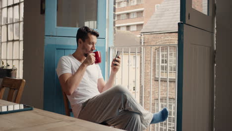 morning coffee for happy man using smart phone at home in pajamas