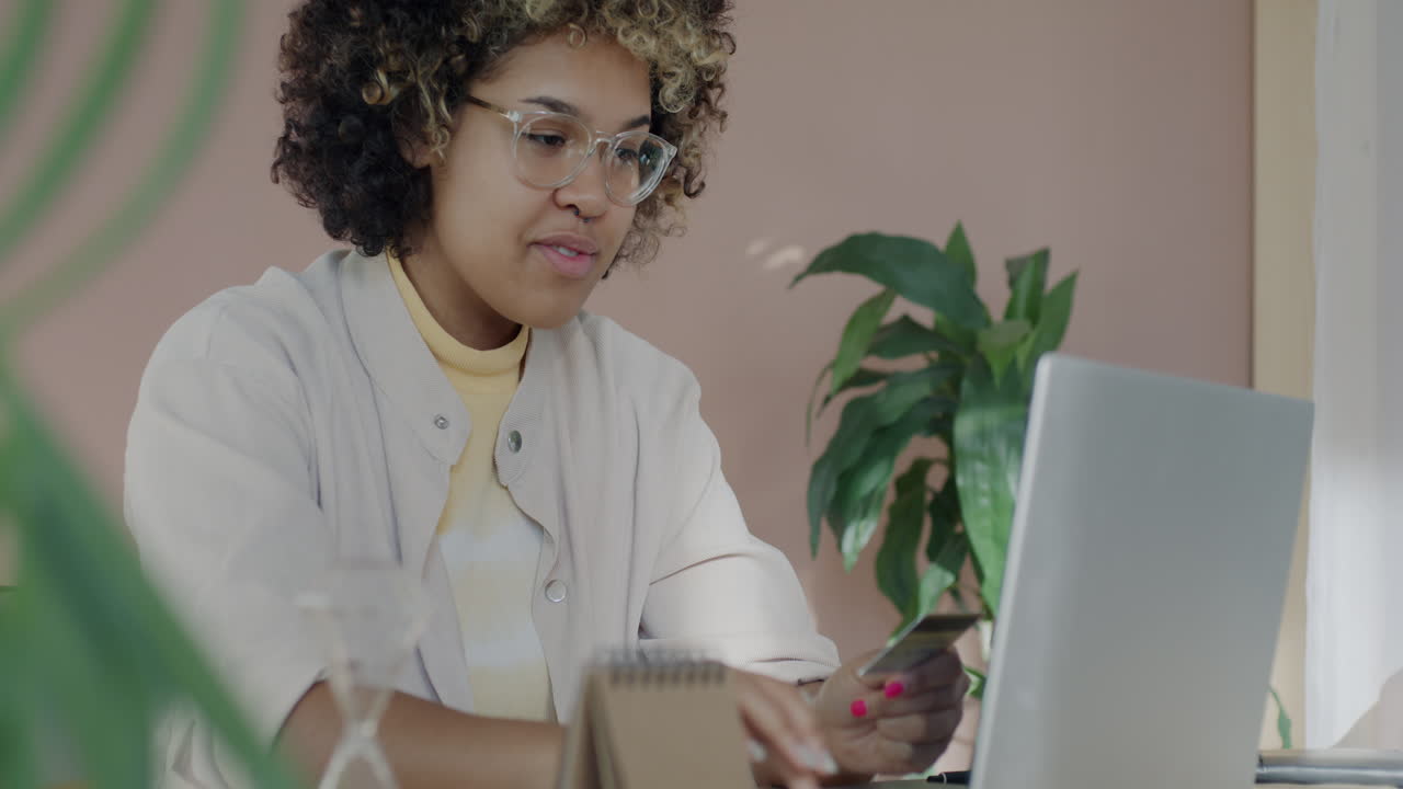 Woman working on laptop and using credit card