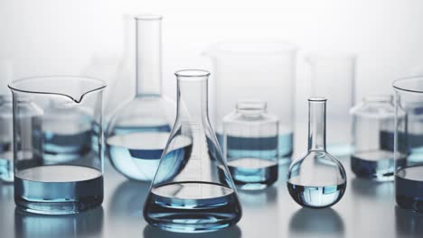 versatile laboratory glassware with blue liquid inside on a light background. many different kinds of chemistry containers stacked in an endless, seamless looping pattern. camera moving sideways.