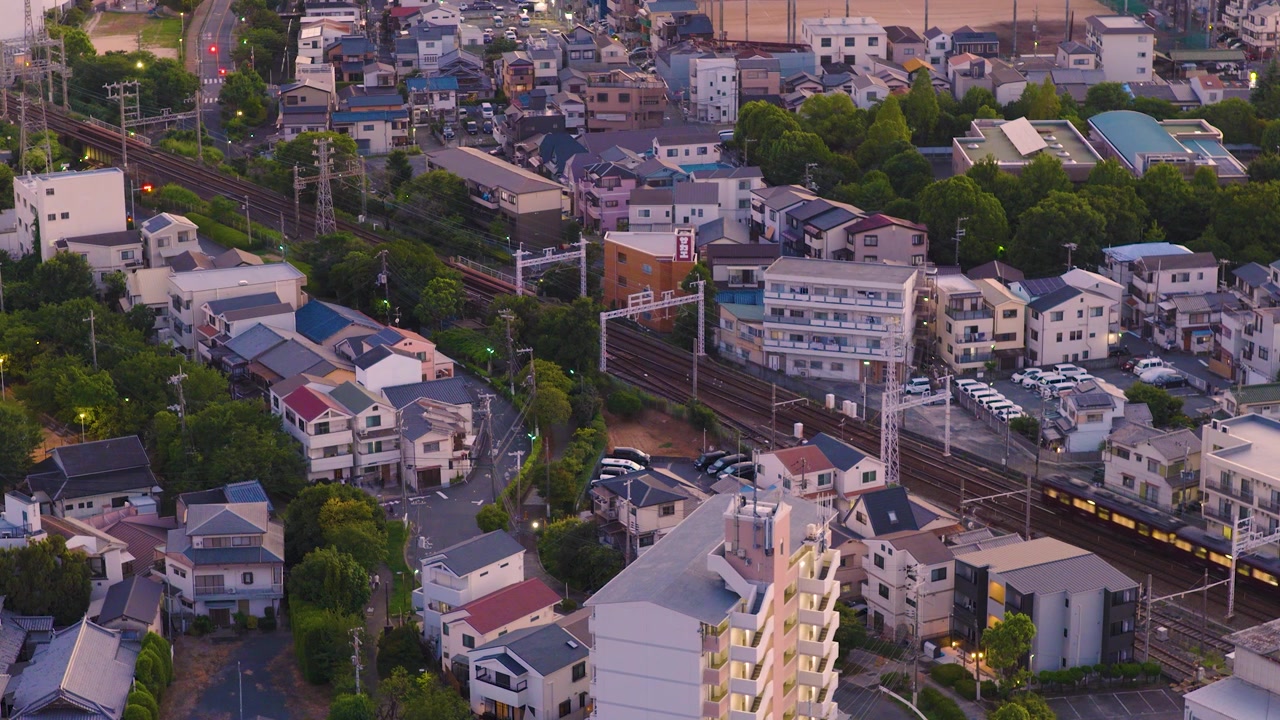 Bairro japonês, trem de passageiros passando à noite, vista aérea de Osaka.