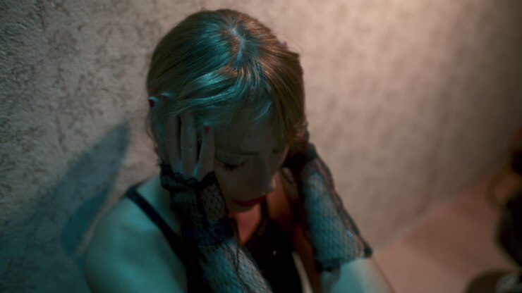 Woman in a Black Dress with Gloves and Dramatic Makeup