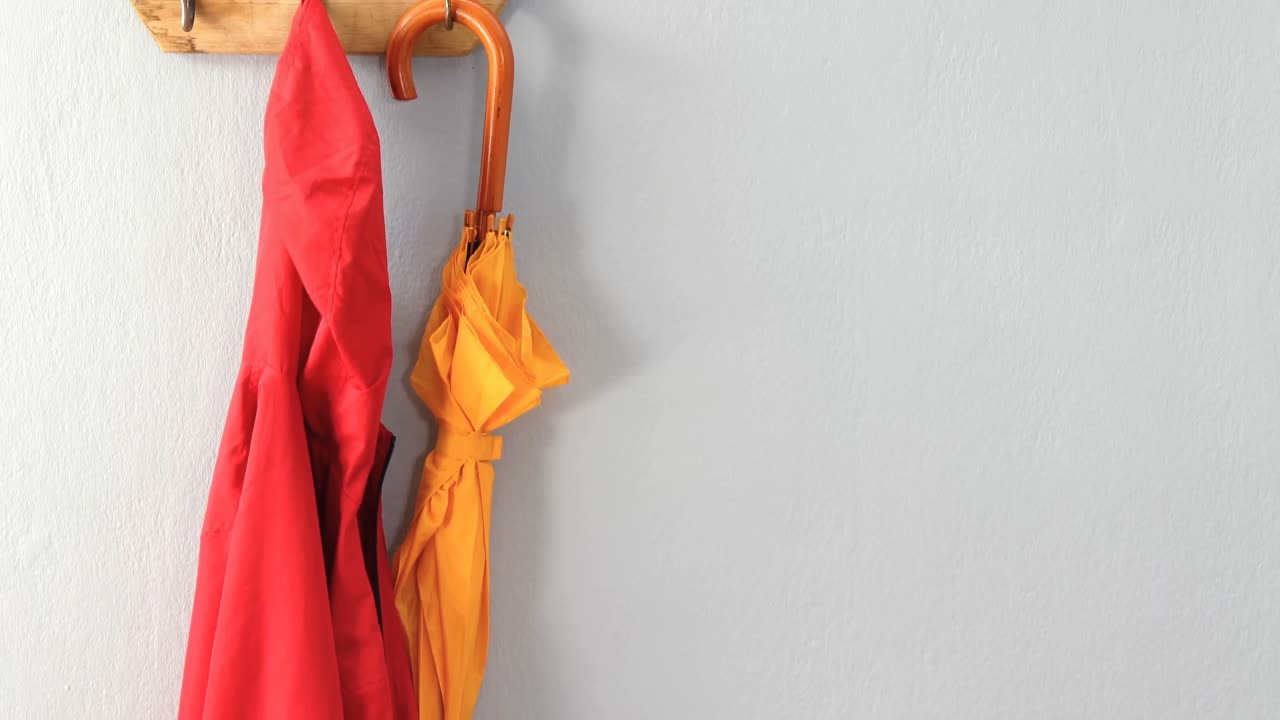 chaqueta y paraguas colgando en el gancho 4k
