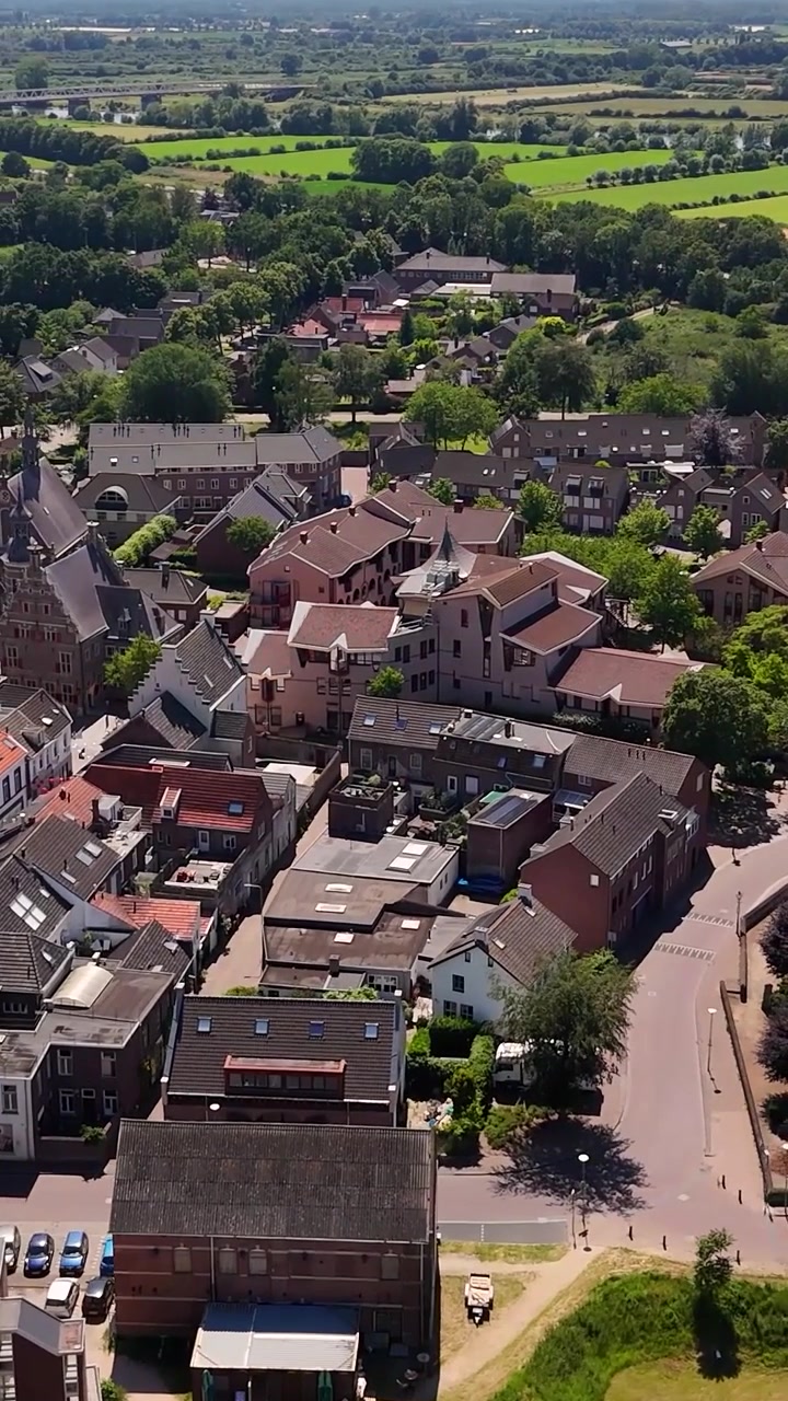 Luchtfoto van een klein Europees stadje met rode pannendaken.