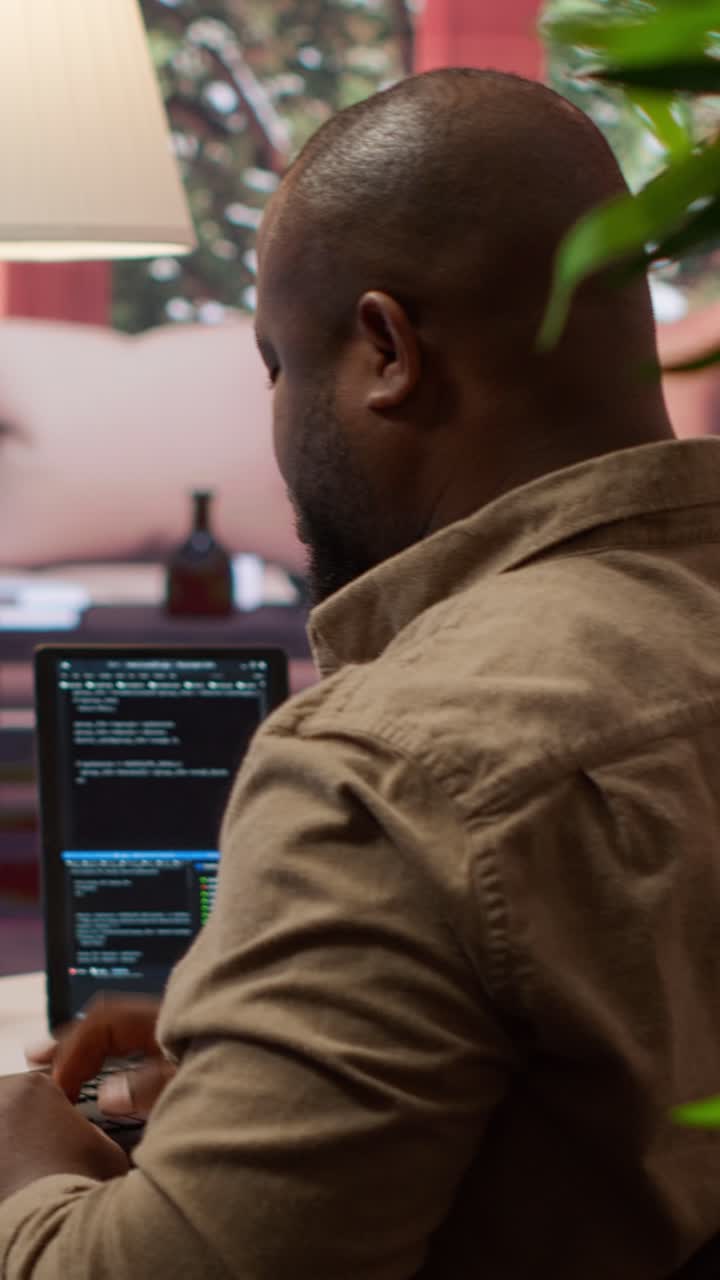 African American Man Typing Code on Laptop at Home