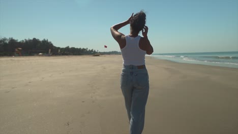 Junge-Frau-Spaziert-Am-Sonnigen-Strand-Entlang-Und-Setzt-Stufen-In-Den-Sand