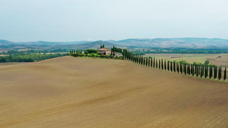 paisaje toscano con entrada de cipreses que conduce a la vila tradicional, bandeja aérea