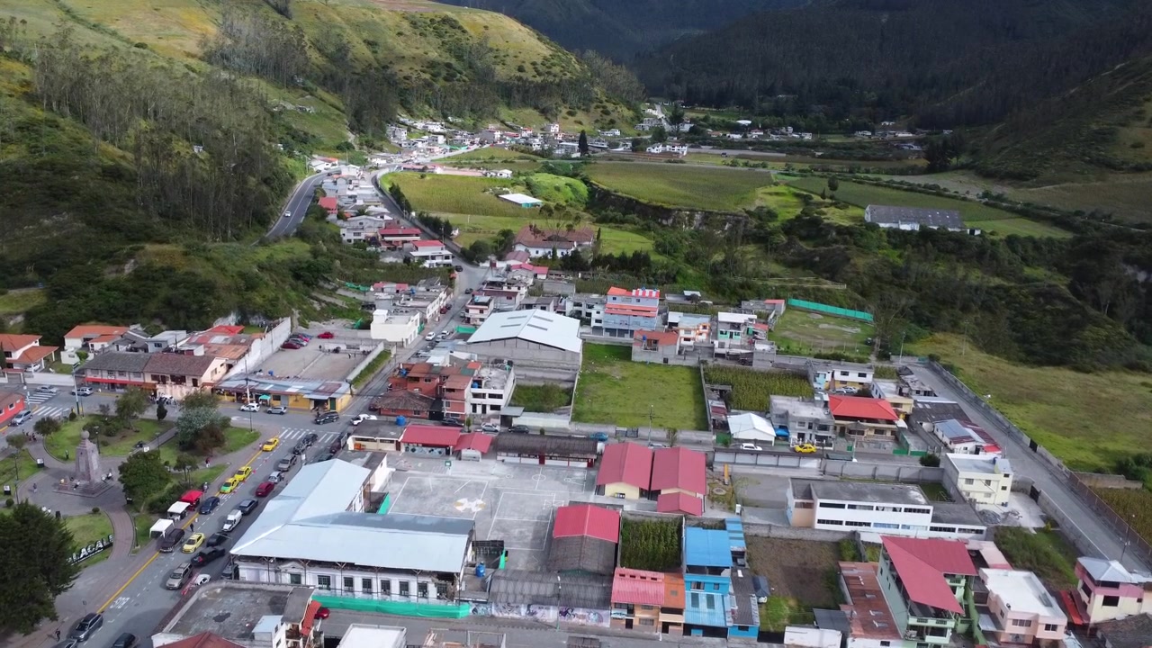 Drone che avanza sopra la città di Calacal, rivelando il paesaggio della valle e il monumento Mitad del Mundo in Ecuador.