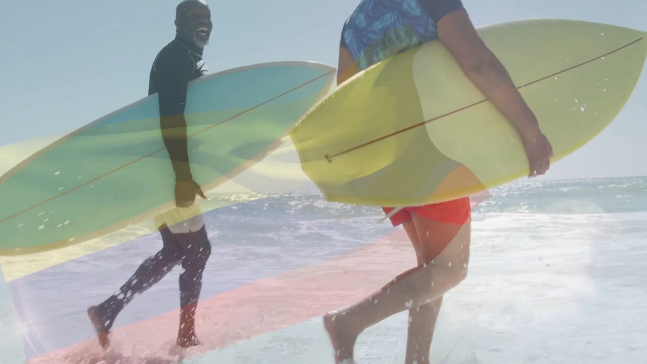 Mies kantaa keltaista lautaa ja nainen vaaleansinisellä laudalla juoksee aaltoihin rantaan surffaamaan.
