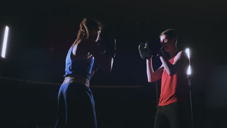 Fitness-Mujer-Atleta-Boxeo-Puñetazos-Enfoque-Guantes-Disfrutando-De-Intenso-Ejercicio-Luchadora-Entrenamiento-Amigo-En-Gimnasio-Entrenamiento-Juntos-Cámara-Lenta