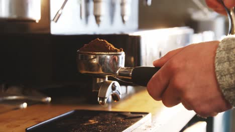 Waiter-pressing-the-coffee-grounds