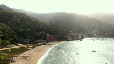 glistening waters of bahia de banderas with beachfront hotels at summer in yelapa, jalisco, mexico. - aerial