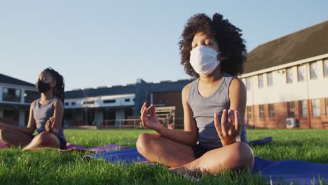 boy wearing face mask performing yoga in the garden