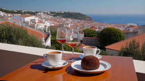 morning coffee and wine on a balcony overlooking a scenic coastal town and the ocean