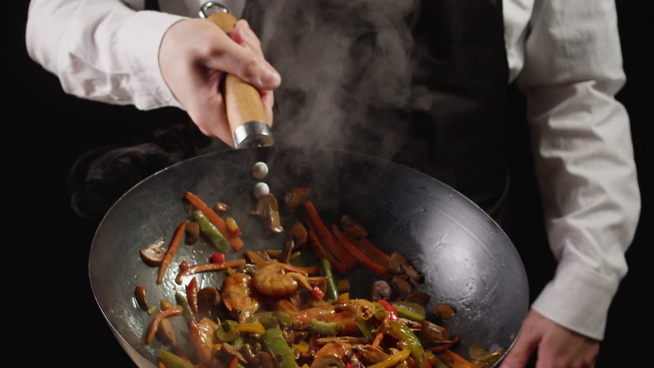 Chef cooking stir-fry in a wok