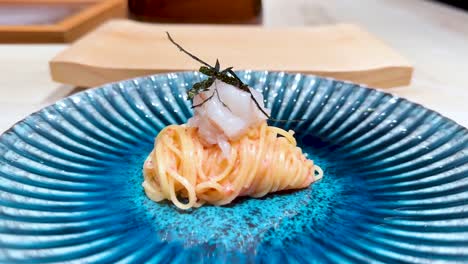 noodles elegantly presented on a blue plate